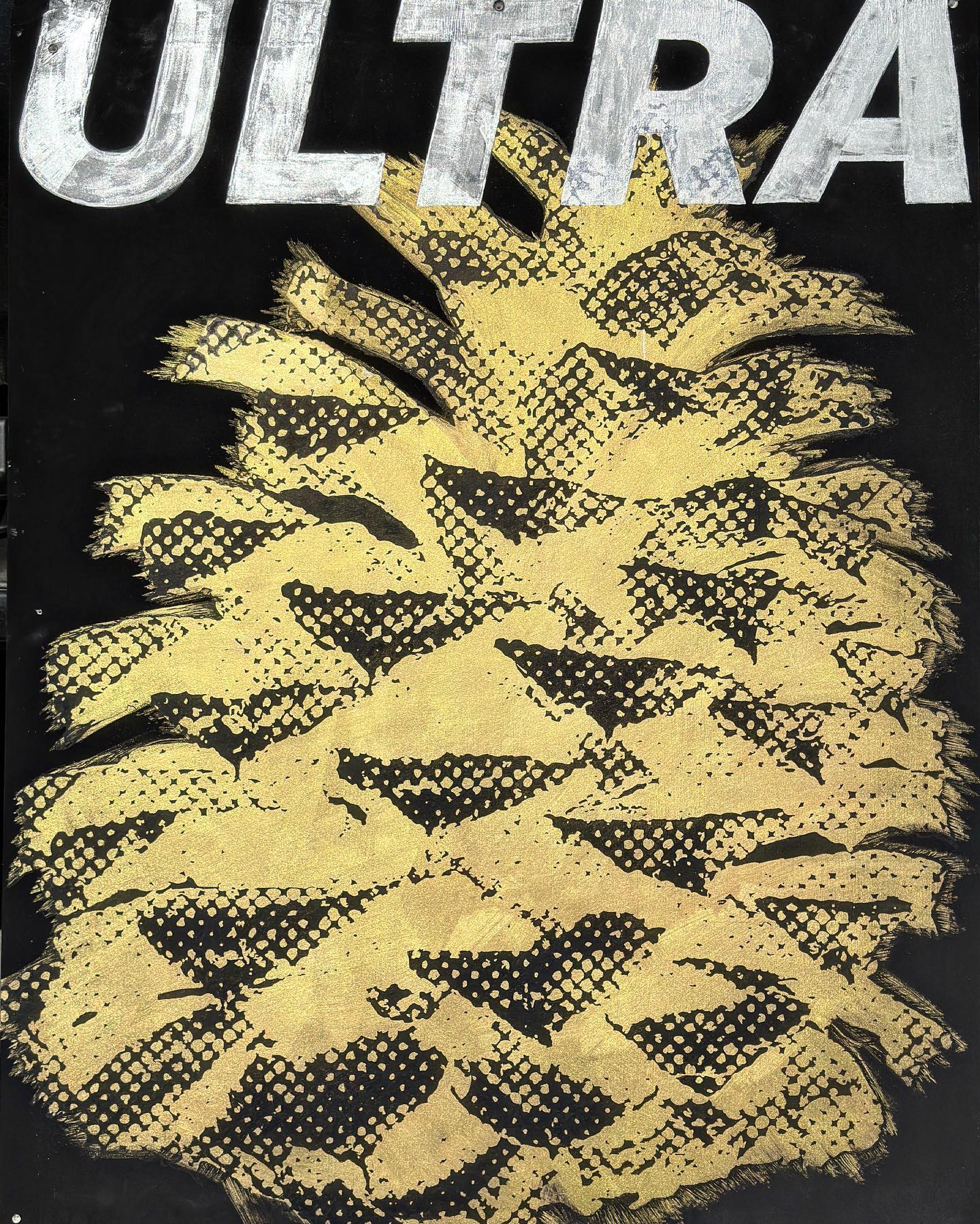 Projekt Ultra, a black-and-gold work built around repeated pinecone forms and large silver lettering.