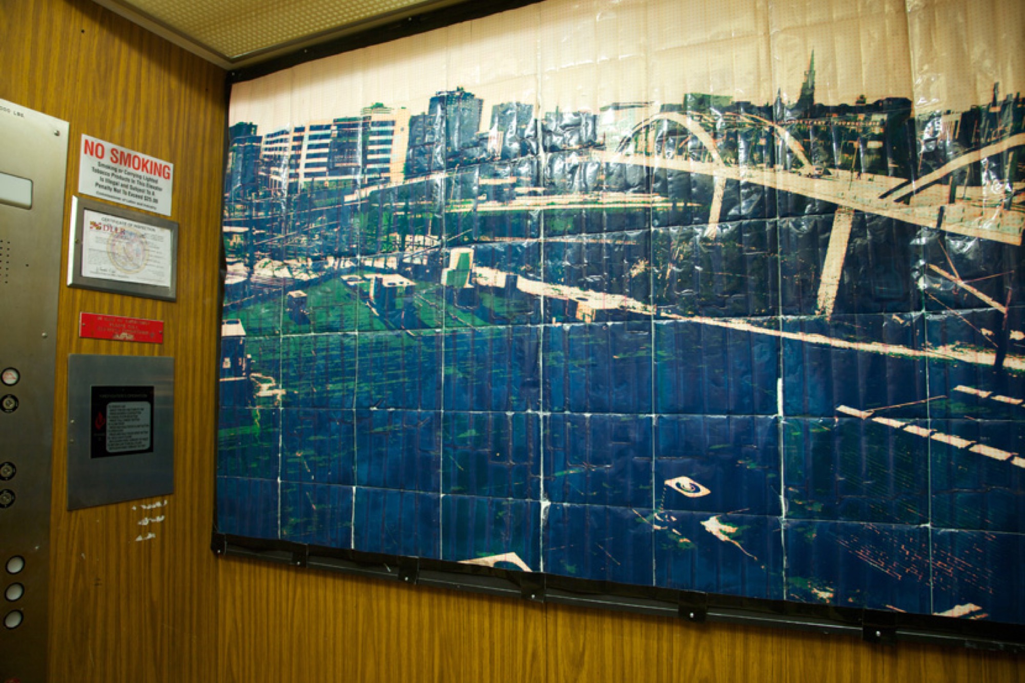 Large tiled city image installed in an elevator for Can You Hear Me Now?