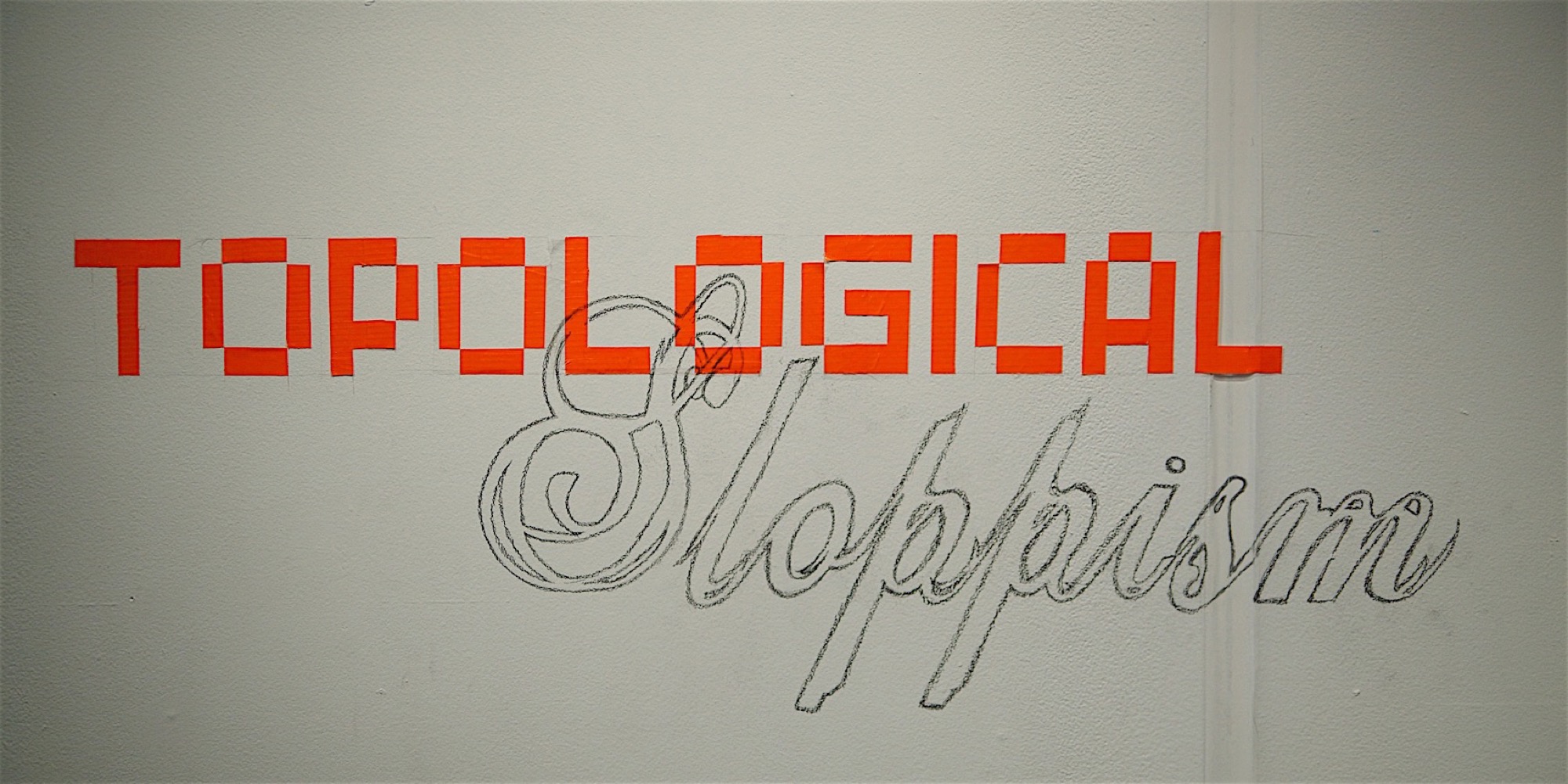 Gallery wall with orange block lettering reading Topological and a scripted second word